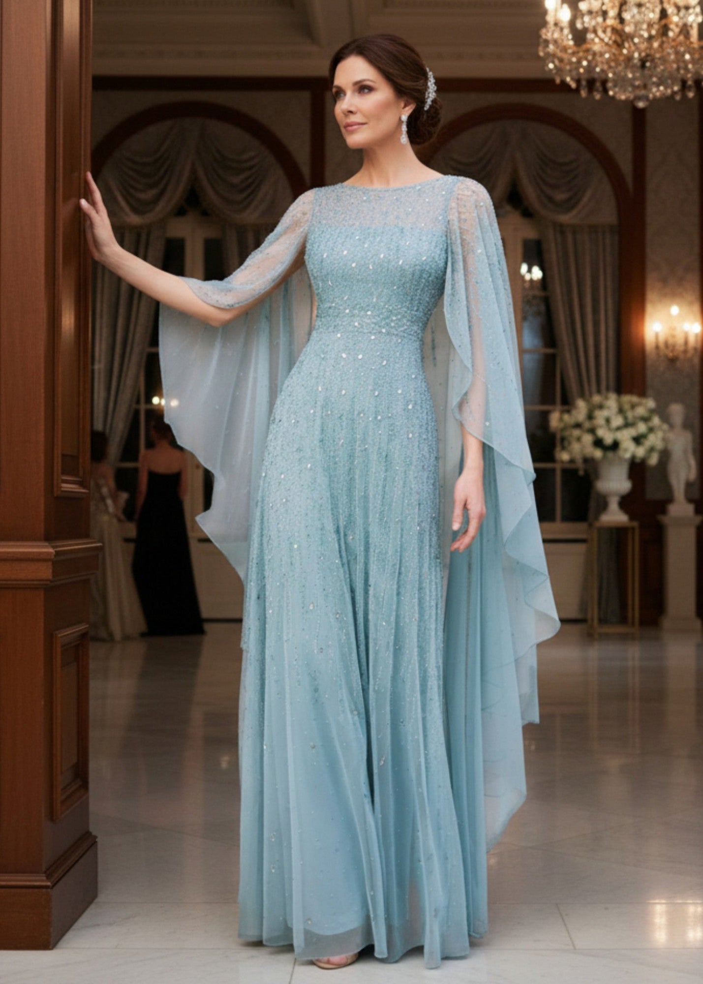 Soft blue beaded mesh gown with a long sheer beaded cape for a formal wedding.