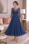 Light navy tea length mother of the bride dress for a formal wedding in chiffon and beaded lace with a 3/4 sleeve.