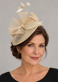 Cream sinamay fascinator with bow loops and feathers on a mature model