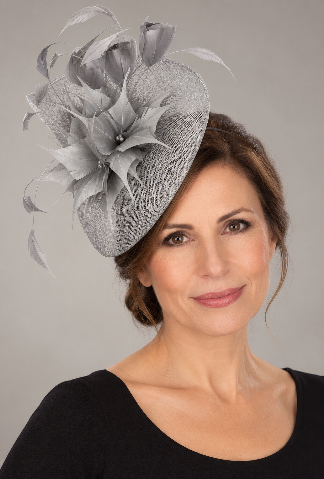 Silver-grey sinamay fascinator with feathers on a mature brunette model