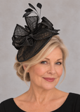 Black open-weave sinamay fascinator on a mature blonde model