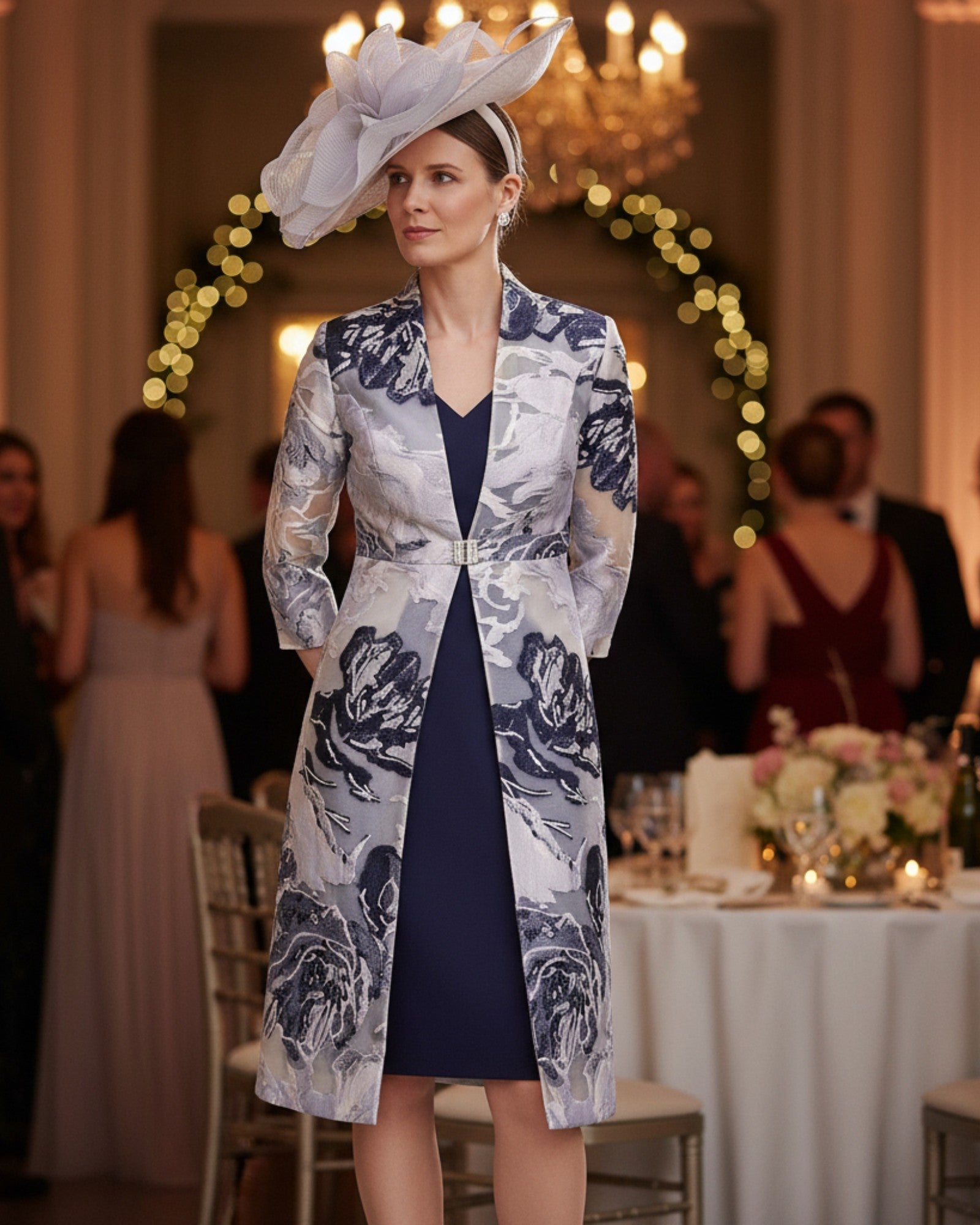 A mother of the bride in a navy crepe dress with a Fil Coupe navy silver coat.
