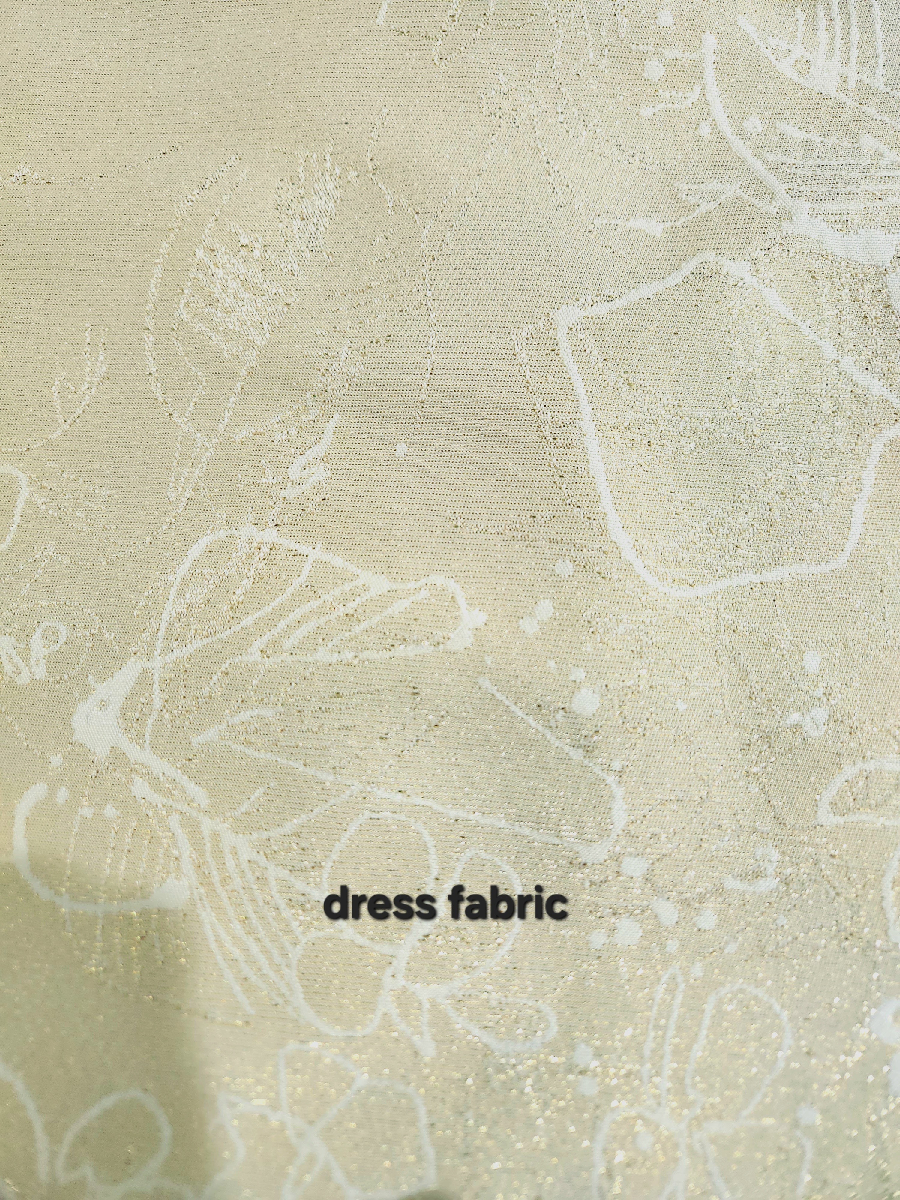 Close-up of buttery cream brocade dress fabric featuring metallic gold thread and subtle floral pattern