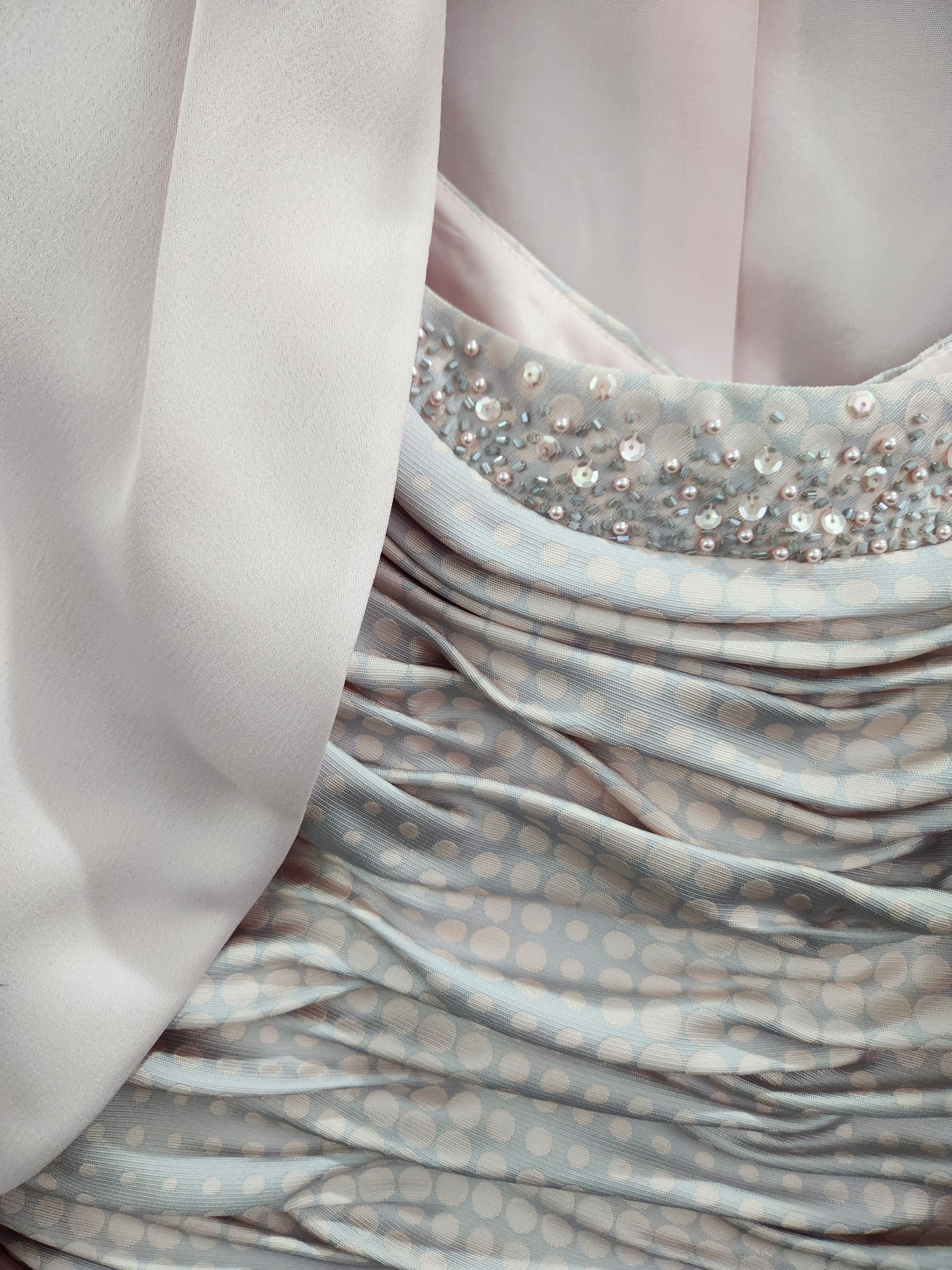Close-up of blush pink metallic occasionwear fabric with textured woven finish and soft sheen