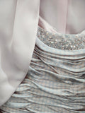 Close-up of blush pink metallic occasionwear fabric with textured woven finish and soft sheen