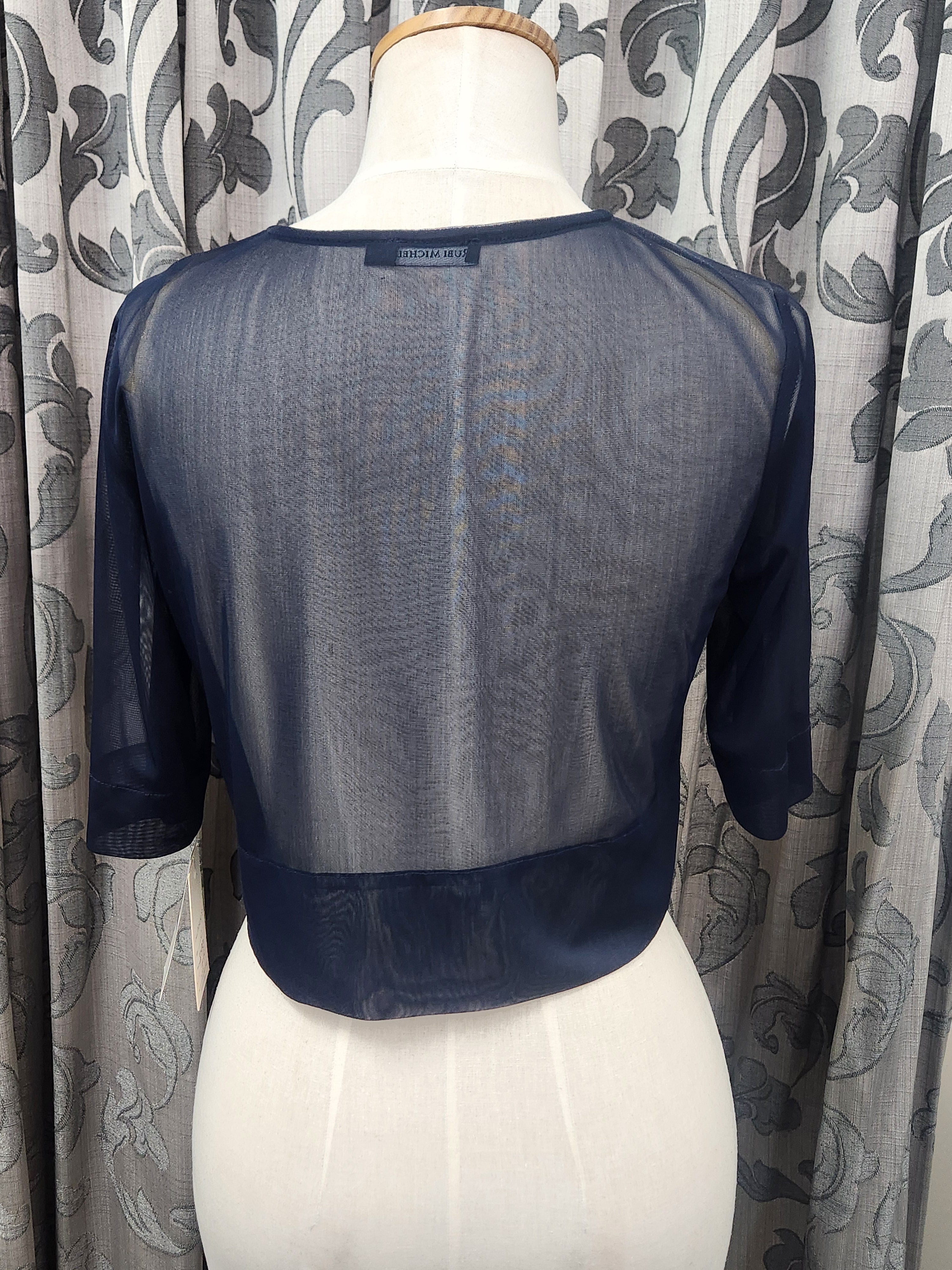 Back view of navy sheer cropped occasion jacket with coordinating trim