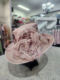 Front view of dusty blush sinamay hat with flowers and feathers