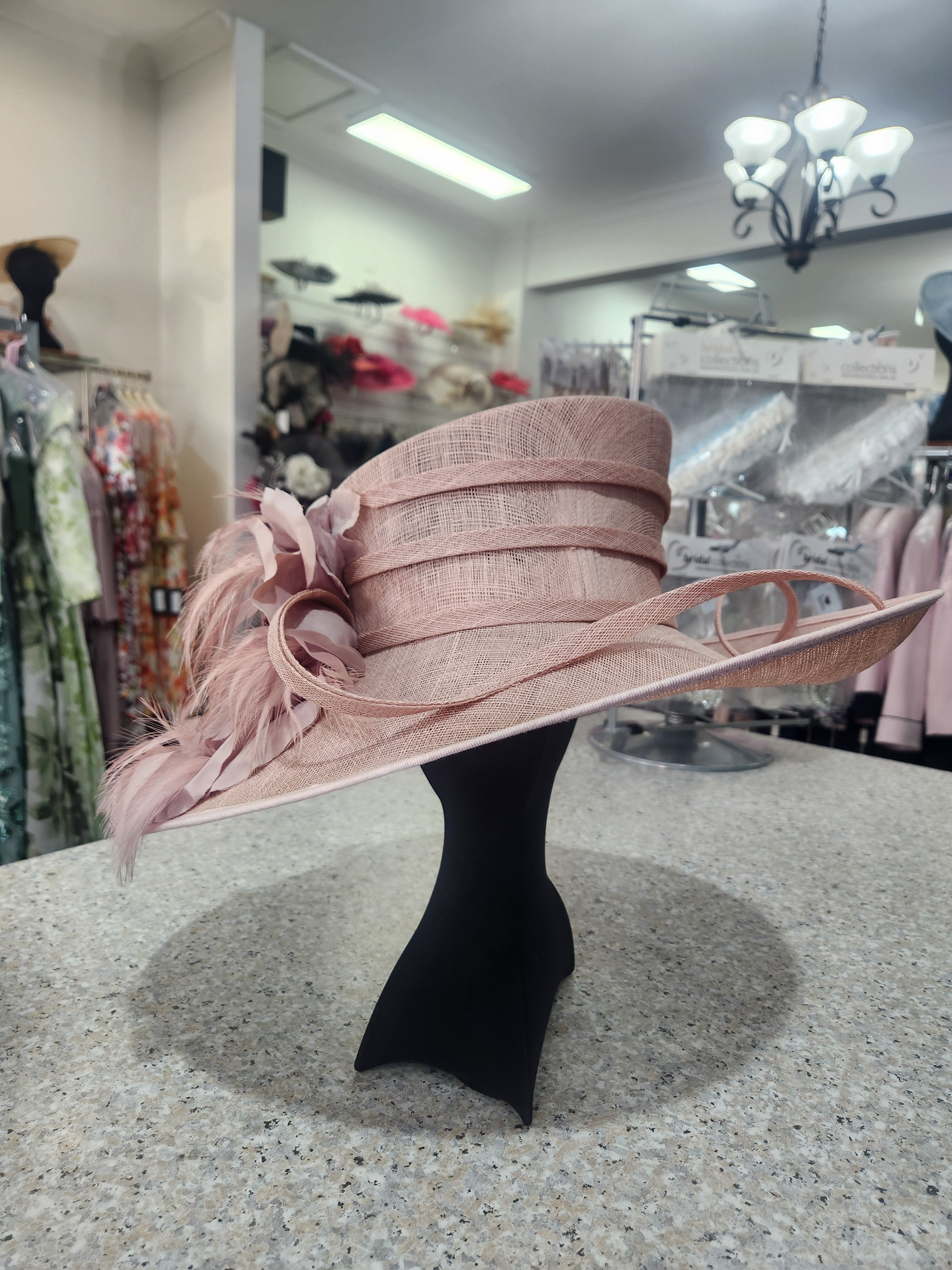 Dusty blush wedding hat with tonal flower and feather decoration