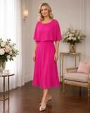 Hot pink chiffon mother of the bride dress by Lizabella with floaty overlay sleeves and tea length skirt