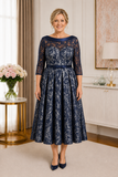 Plus size navy mother of the bride dress with 3/4 lace sleeves and flattering waistband