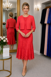 Coral lace mother of the bride outfit with matching cropped jacket and fluted hem dress, shown on a size 12–14 model with formal updo hairstyle in the Ever Elegant Melbourne boutique.