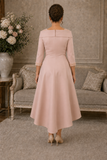 Back view of Couture Club peach pink Mikado dress with pearl cuffs and longer hem