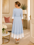 Elegant blue wedding guest dress with embroidered shoulder detail, flowing tea-length skirt and back view styling for mature women