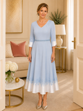 Soft blue mother of the bride tea-length dress with embroidered hem detail and three-quarter sleeves, back view, formal occasion wear Australia