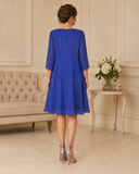 Back view of royal blue dress and flowing sheer chiffon coat with three-quarter sleeves.