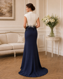 Back view of Couture Club navy and cream gown with long skirt and subtle train