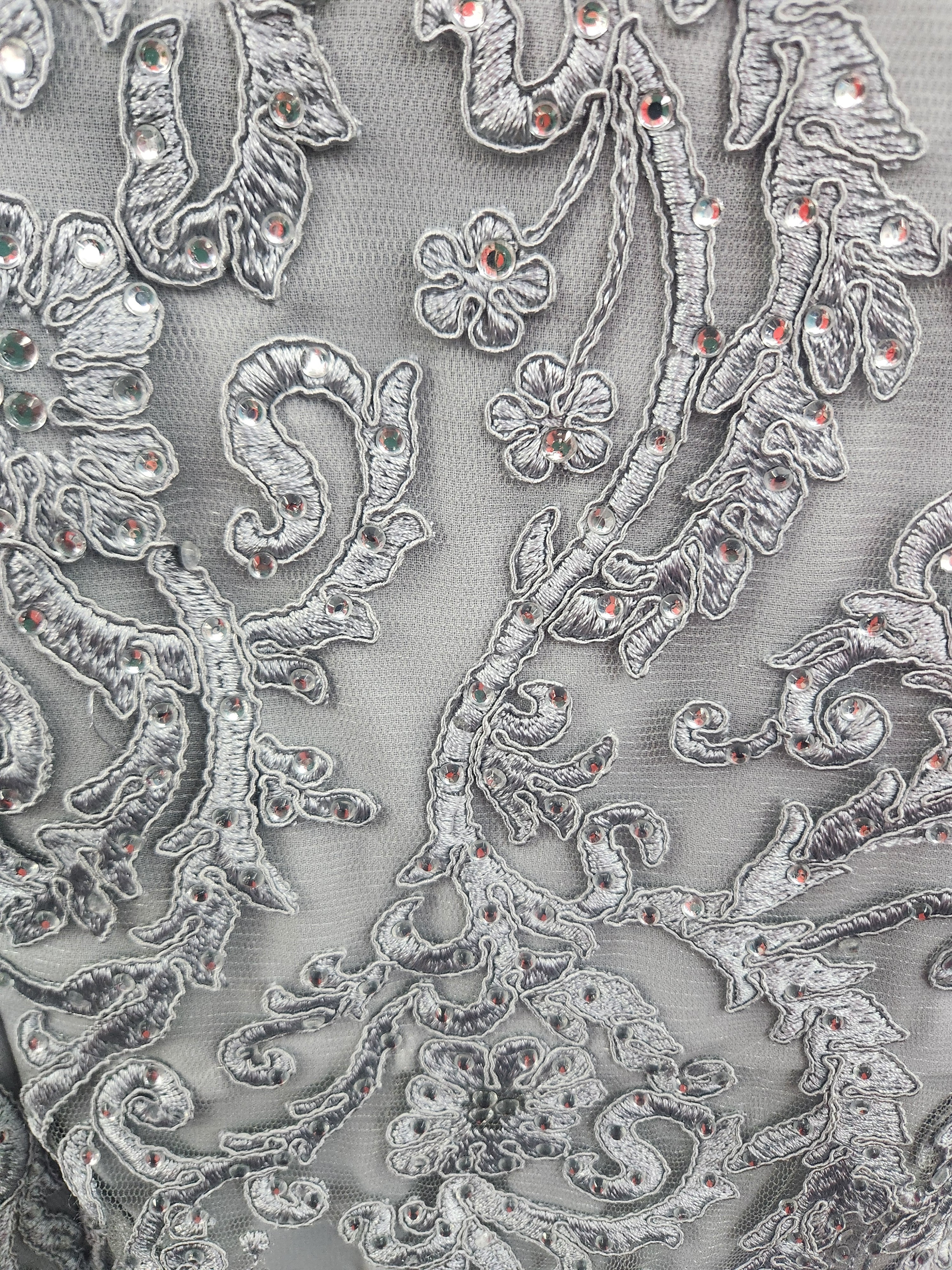 close up of the silver lace  on the bodice of a mother of the bride dress in chiffon and lace.
