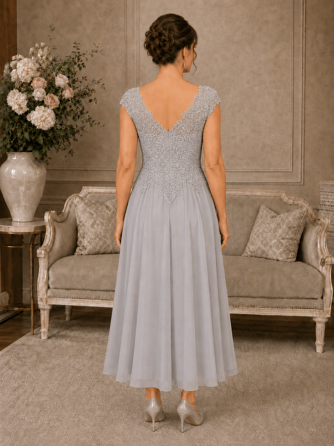 Back view of silver-grey occasion dress with illusion V-back, beaded lace and flowing chiffon skirt