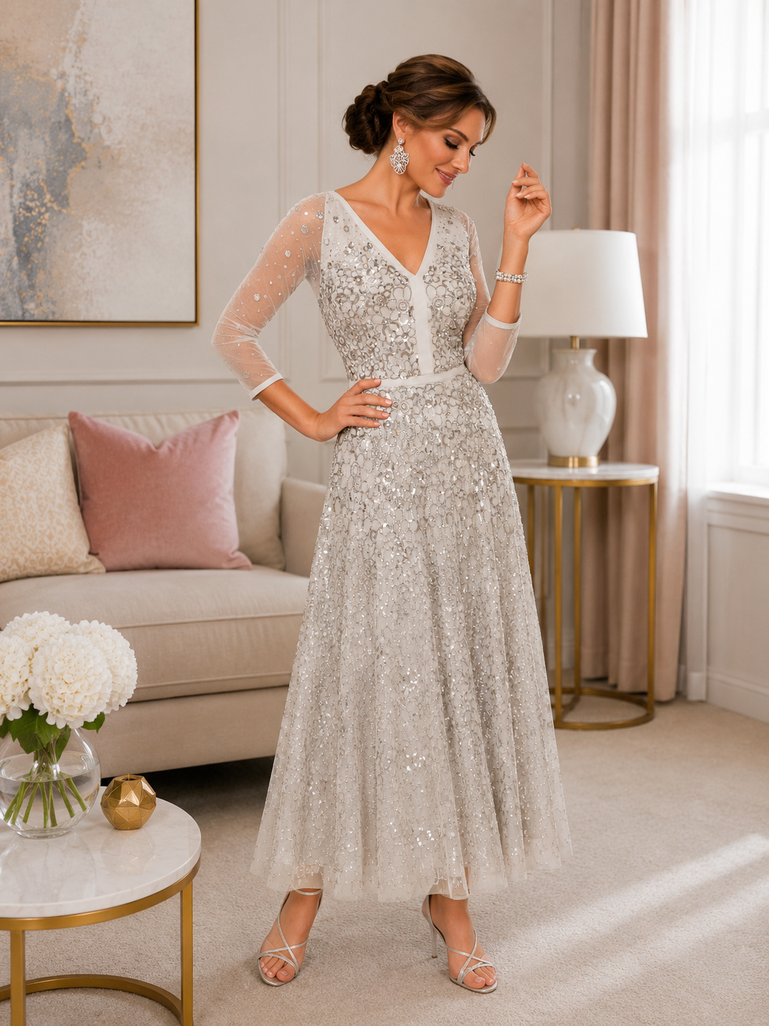 Silver embellished tea-length occasion dress with sheer three-quarter sleeves, fitted bodice and flowing A-line skirt, styled for mother of the bride or mother of the groom in an elegant indoor boutique setting.