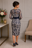Back view of Veni Infantino navy floral mother of the bride dress with sheer lace sleeves, fitted silhouette and bateau neckline on brunette model at Ever Elegant Melbourne