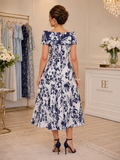 Back view of navy and ivory occasion dress with structured collar, fitted waist and flared floral skirt.
