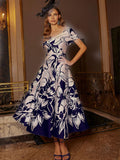 Elegant mother of the bride dress in navy and blush floral brocade with fit-and-flare silhouette and beaded shoulder detail