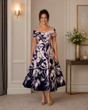 Front view of blush pink and navy floral mother of the bride dress with embellished shoulders and full A-line skirt.