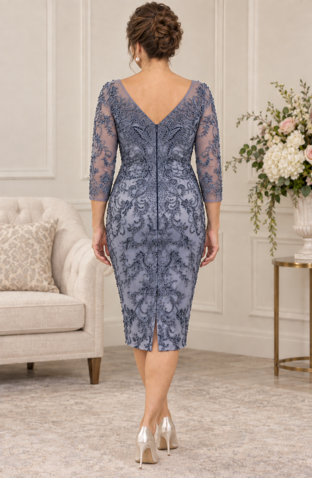 Back view of a blue-grey beaded occasion dress with a V-shaped neckline, centre-back zip and small skirt vent.
