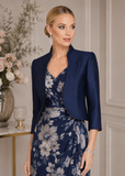 Navy mikado mother of the bride jacket styled over a floral occasion dress in an elegant formal setting