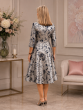 Back view of silver and navy floral brocade occasion dress with fitted bodice, 3/4 sleeves and full A-line skirt