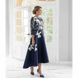 Mother of the bride dress in a floral brocade with a bardot neckline and a high low hemline.