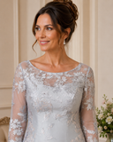 Close-up of silver brocade occasion dress showing sheer floral embroidered neckline and sleeve detail