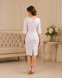 Elegant blush pink wedding guest dress with subtle brocade pattern, fitted silhouette and below-the-knee length