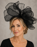 Blonde woman wearing a black Max Alexander sculptural mesh fascinator for a wedding or race-day event