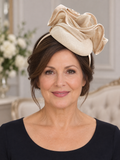Front view of mature model wearing a cream sinamay wedding fascinator