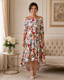 Ivory floral off-the-shoulder occasion dress with three-quarter sleeves and a shorter front hem.