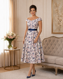 Silvery pink floral brocade mother of the bride dress with navy waistband and asymmetric folded neckline.