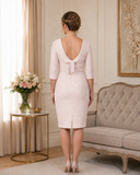 Back view of soft pink occasion dress with deep V-back, bow detail and subtle rose metallic finish