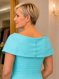 Close-up of Veromia turquoise occasion dress showing pleated bodice, off-the-shoulder neckline and intricate button detail.