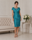 Teal mother of the bride dress with illusion lace neckline, pleated satin bodice and fitted knee-length skirt