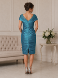 Back view of teal wedding guest dress with V-back, ruched stretch taffeta and centre back slit