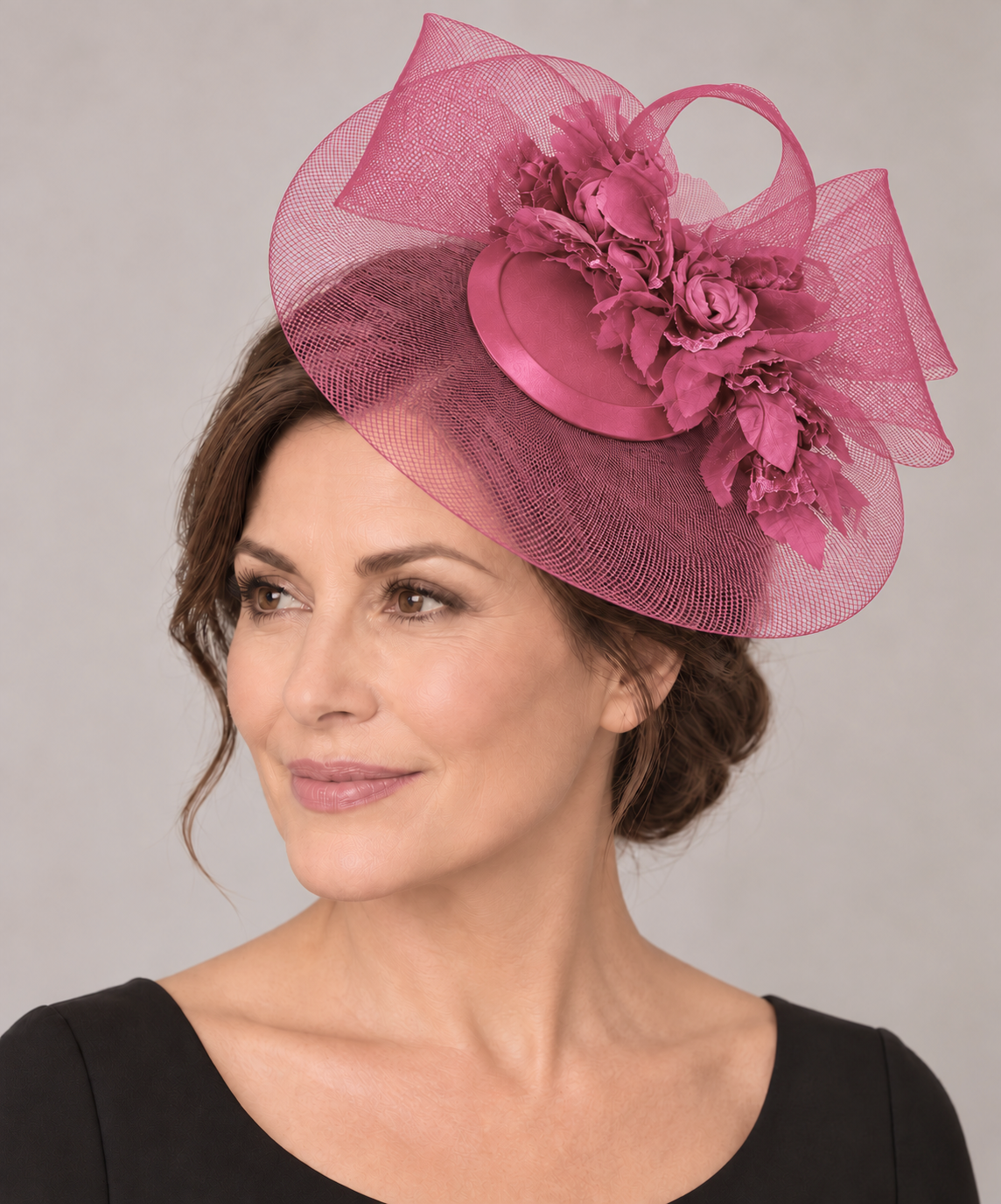 Fuchsia fascinator worn beside the crown by a mature brunette model