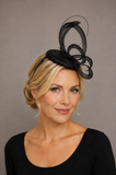 Blonde woman wearing a small black disc fascinator with sculptural loops