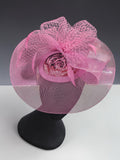 Pink mesh wedding fascinator with sculptural netting and floral centre detail