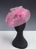 Close-up of pink occasion fascinator with patterned fabric centre and mesh loops