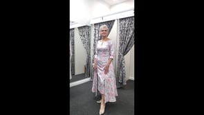 video of a silver and brocade mother of the bride dress with a fitted top,3/4 sleeves and middy length skirt.