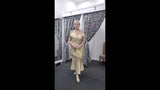 A video  showcasing a cream gold off-the-shoulder mother of the bride dress with draped front detail, fitted silhouette and elegant movement in an indoor boutique setting.