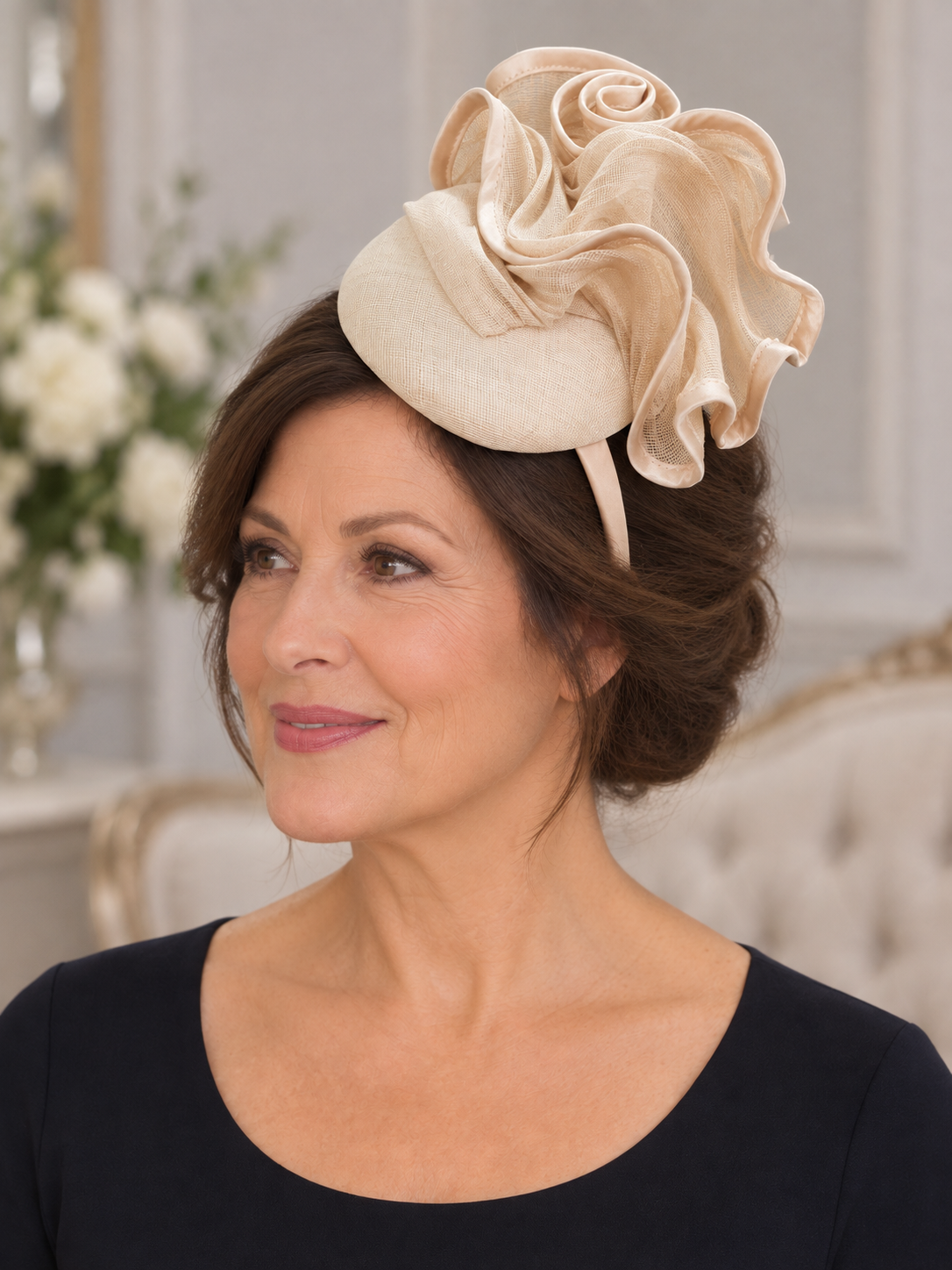 Side view of cream pillbox fascinator showing layered sinamay loops