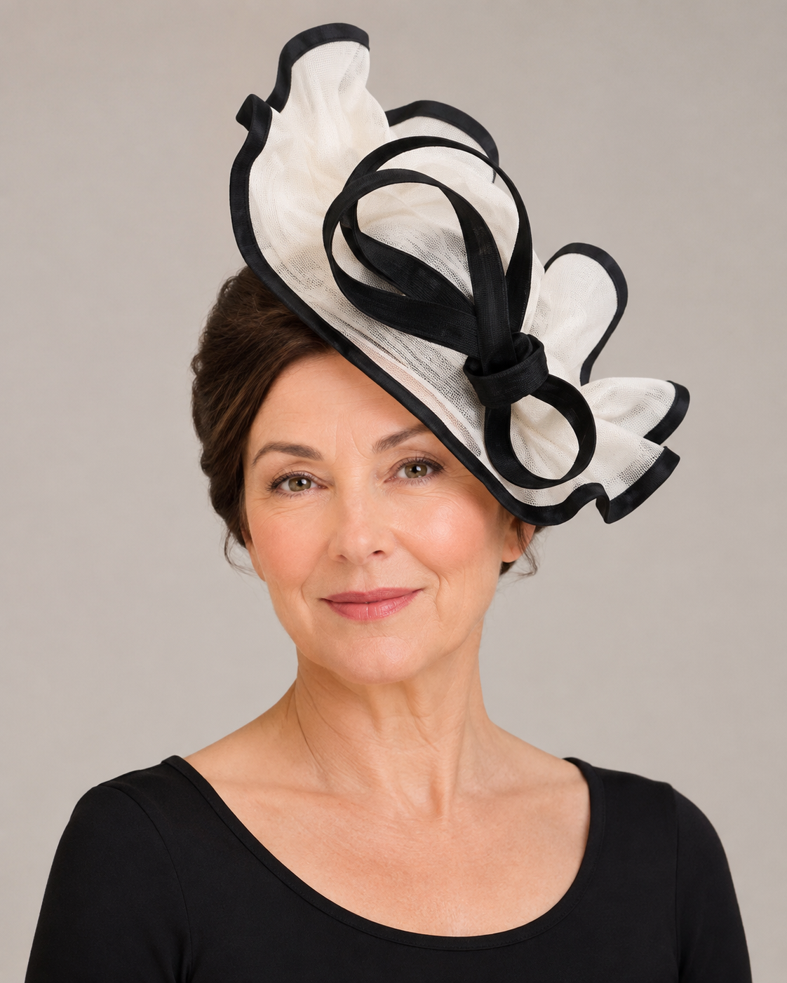 Mature woman wearing an elegant black and ivory fascinator for weddings and special occasions