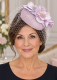 Mature brunette model wearing a lilac and blush-pink fascinator